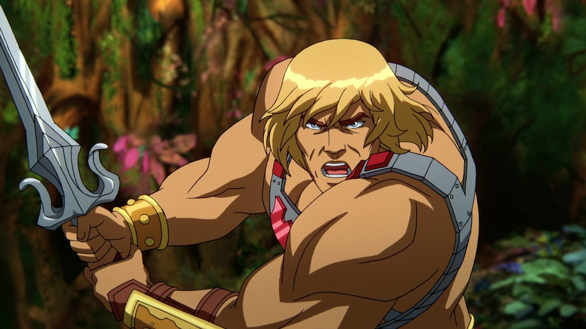 In a CG animated still from Masters of the Universe: Revelation, He-Man wears a silver chest plate with a red "H" in the center and golden wrist plates. He is holding a silver sword with both hands with his mouth open. The foliage of the forest is visible behind him.